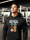 Man wearing black gym hoodie with donut six pack graphic design in fitness gym setting