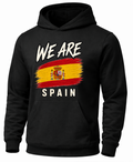 A black pullover hoodie featuring a graphic print of the Spanish flag with the text 'WE ARE' above and 'SPAIN' below, shown on a plain white background.