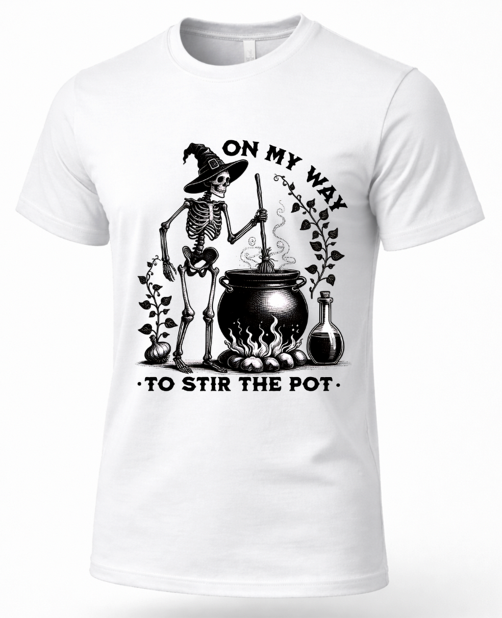 A white short-sleeve crewneck t-shirt featuring a black graphic of a skeleton wizard stirring a cauldron with the text 'ON MY WAY TO STIR THE POT'.