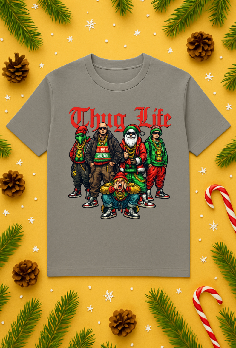 Gray t-shirt with a colorful “Thug Life” Santa crew Christmas graphic, displayed on a festive yellow background with pine branches, candy canes, and pinecones