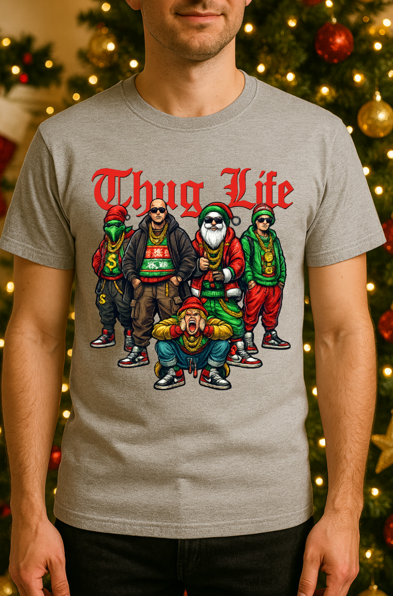 Gray “Thug Life” Christmas crew graphic tee displayed on a model in front of a decorated holiday tree with lights and ornaments.