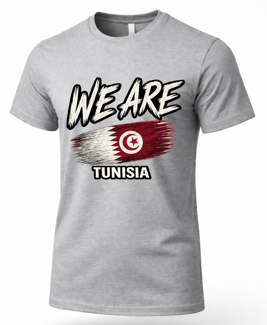 A heather gray short-sleeve t-shirt with a graphic print on the front. The graphic features the text 'WE ARE' in a stylized black and white font above a distressed Tunisian flag design, with 'TUNISIA' printed below in black.