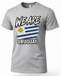 A heather gray short-sleeve t-shirt featuring a graphic print of the Uruguayan flag with the text 'WE ARE URUGUAY' in a bold, stylized font.