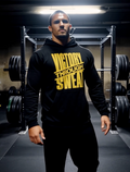Man wearing black gym hoodie with “Victory Through Sweat” motivational fitness quote in weightlifting gym