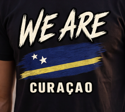 Close-up of a black T-shirt worn by a person, featuring a graphic print with the words 'WE ARE' and 'CURAÇAO' and a stylized blue and yellow flag design with white stars.