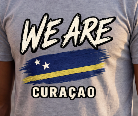 A close-up of a heather gray t-shirt featuring a graphic print with the text 'WE ARE' and 'CURAÇAO' surrounding a blue and yellow flag design.