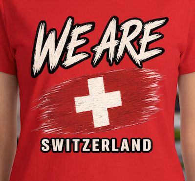 A close-up of a red short-sleeve T-shirt worn by a person, featuring a distressed white Swiss cross over a red brushstroke graphic, with the words 'WE ARE' above and 'SWITZERLAND' below in white outlined lettering.