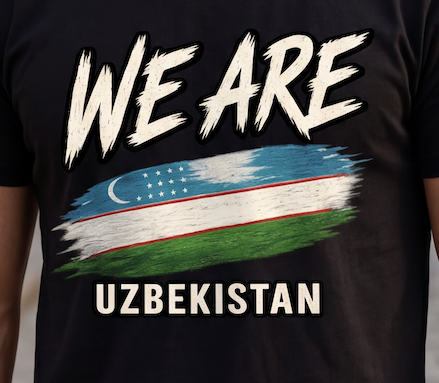 A close-up of a black t-shirt featuring a graphic print with the text 'WE ARE' in a distressed white brush font, followed by a stylized flag design in blue, white, red, and green, and 'UZBEKISTAN' printed below in white.