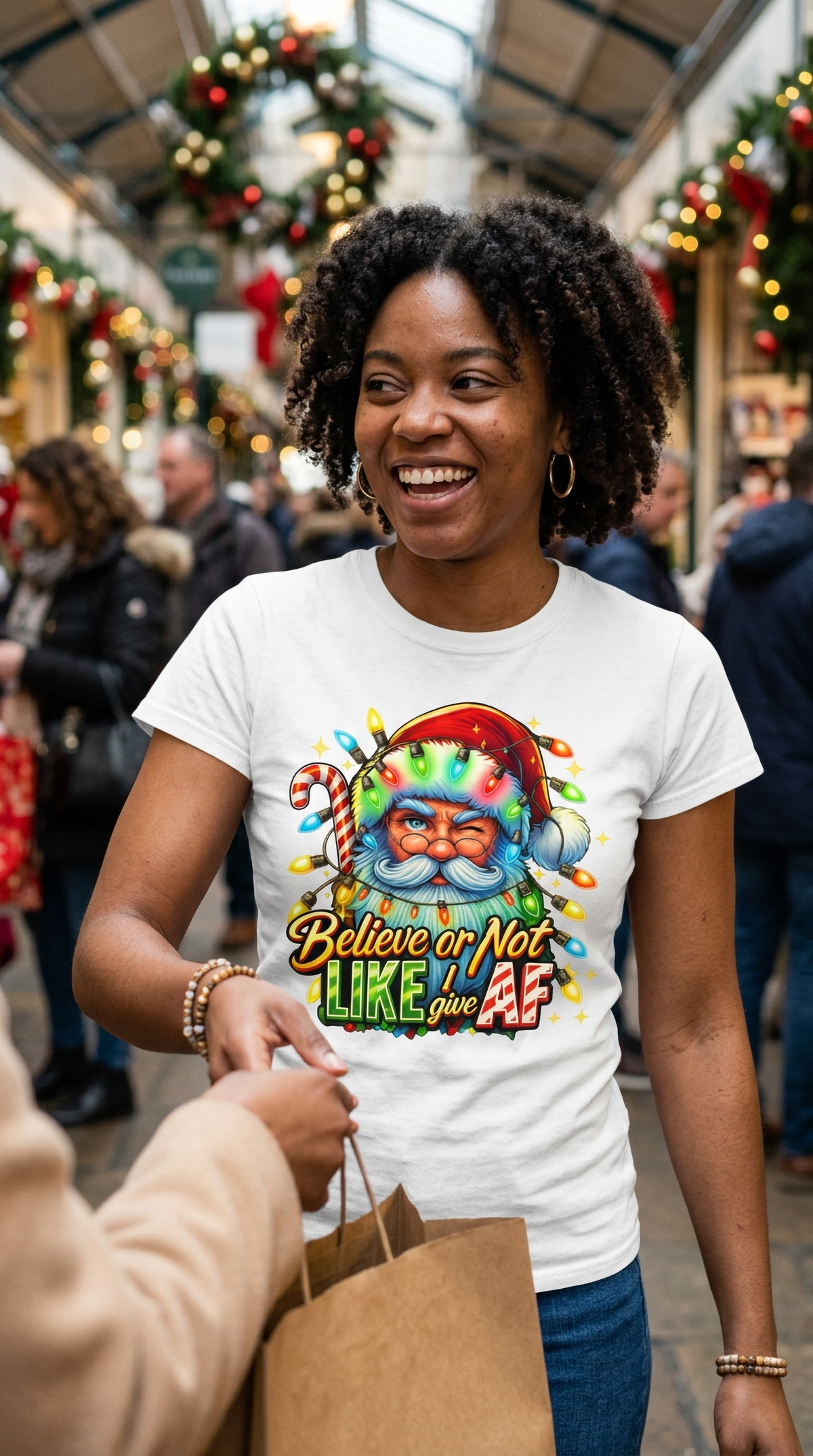 Lifestyle – White: Woman wearing a white sarcastic Santa Christmas graphic t-shirt at a festive indoor holiday gathering.