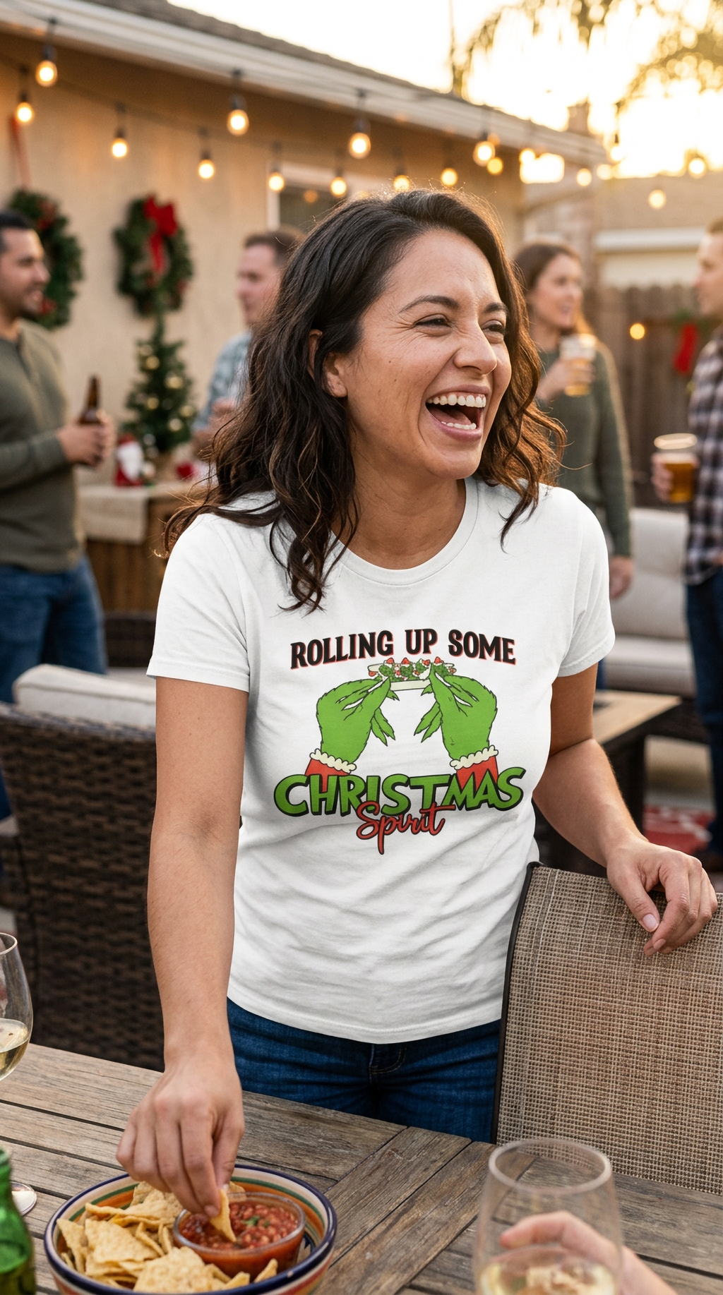 Woman wearing white Rolling Up Some Christmas Spirit t-shirt at an outdoor restaurant decorated for the holidays.