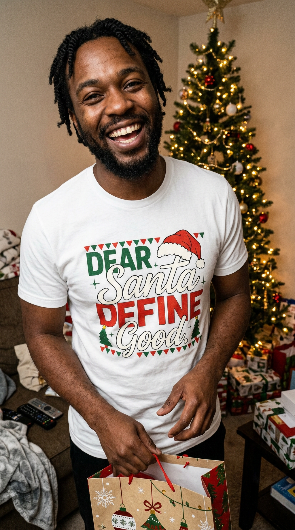 Lifestyle – White: Man wearing a white Dear Santa Define Good funny Christmas graphic tee at a holiday gathering near a decorated Christmas tree.