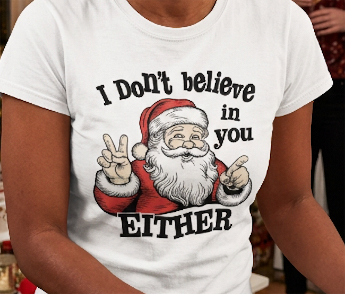 Close-up of white funny Christmas graphic tee featuring Santa Claus pointing and I Don't Believe in You Either text.
