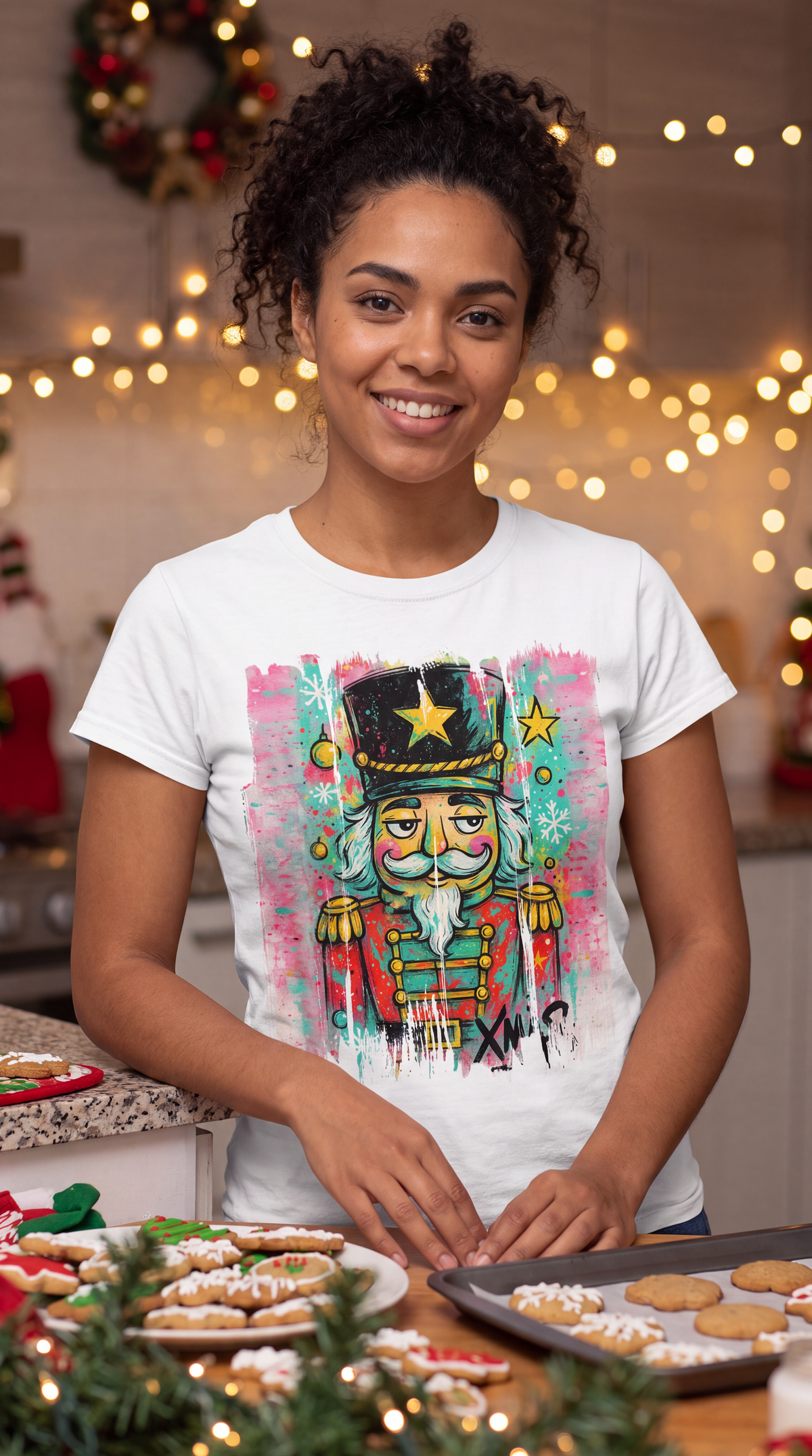 Woman wearing white graffiti nutcracker Christmas graphic shirt in holiday setting