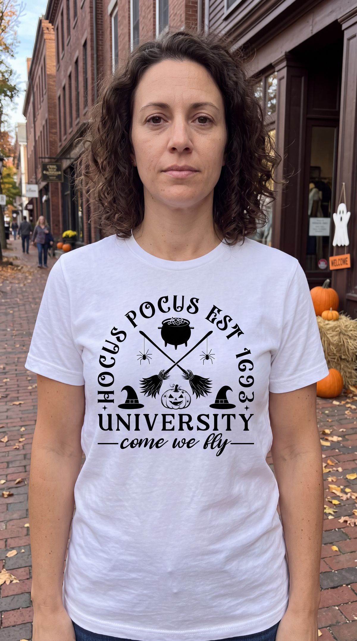 Woman wearing white Hocus Pocus University Come We Fly Halloween shirt outdoors