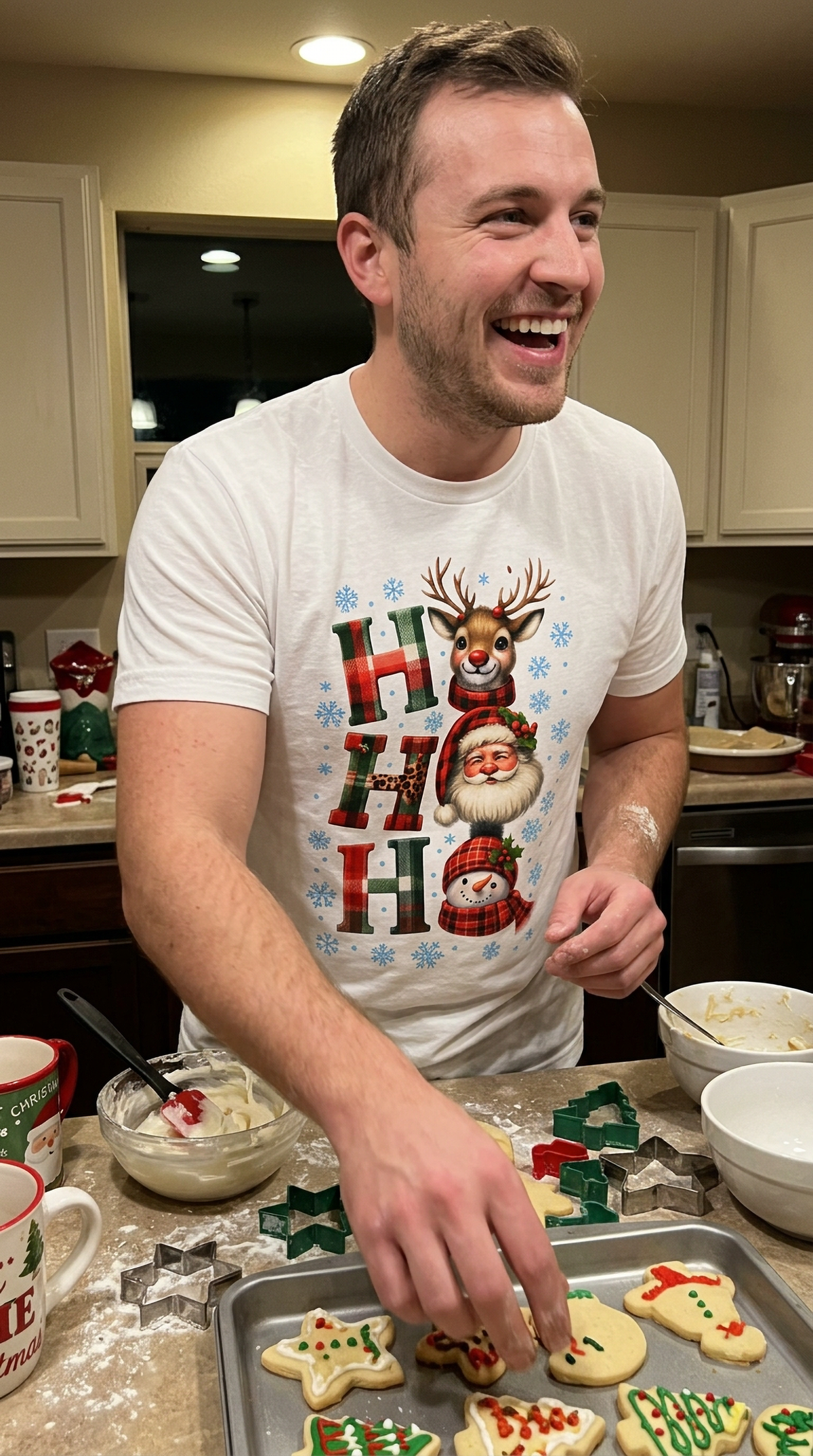 Smiling man wearing white Ho Ho Ho Christmas graphic tee at a festive holiday gathering.