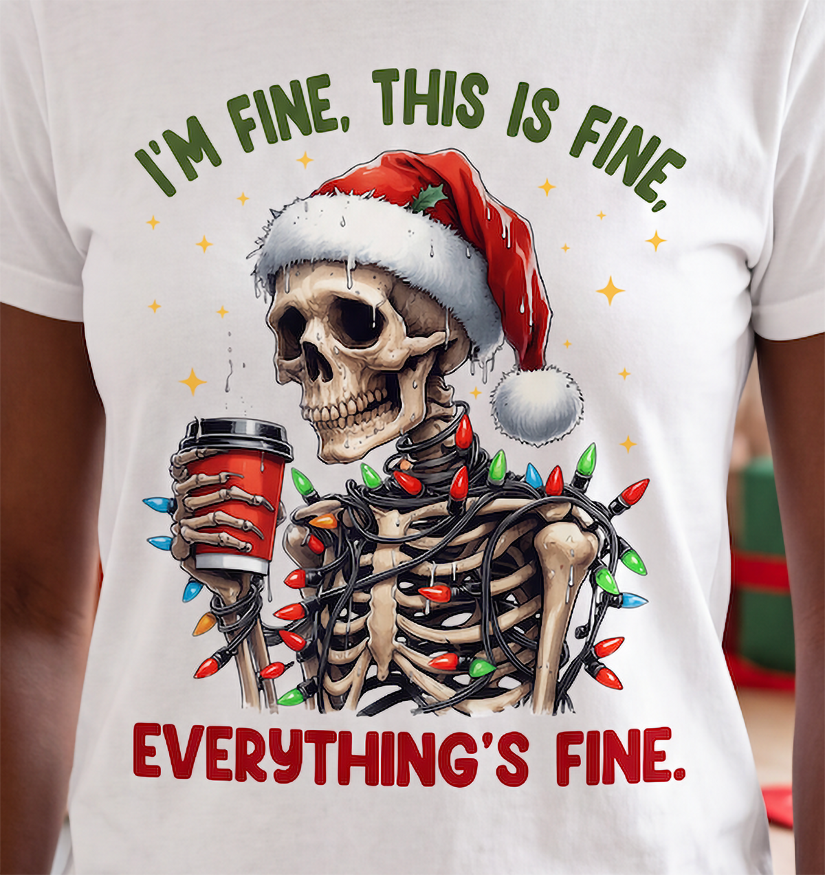 Close-up of I’m Fine Everything’s Fine skeleton Christmas graphic on white shirt.