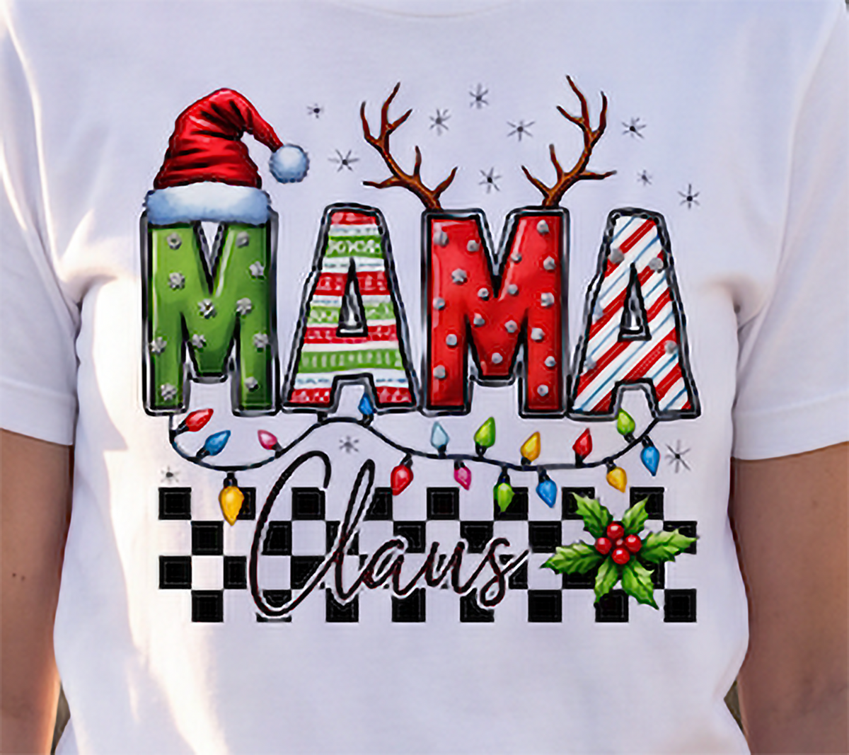 Close-up of white Mama Claus Christmas graphic tee featuring Santa hat, antlers, holiday lights and holly.