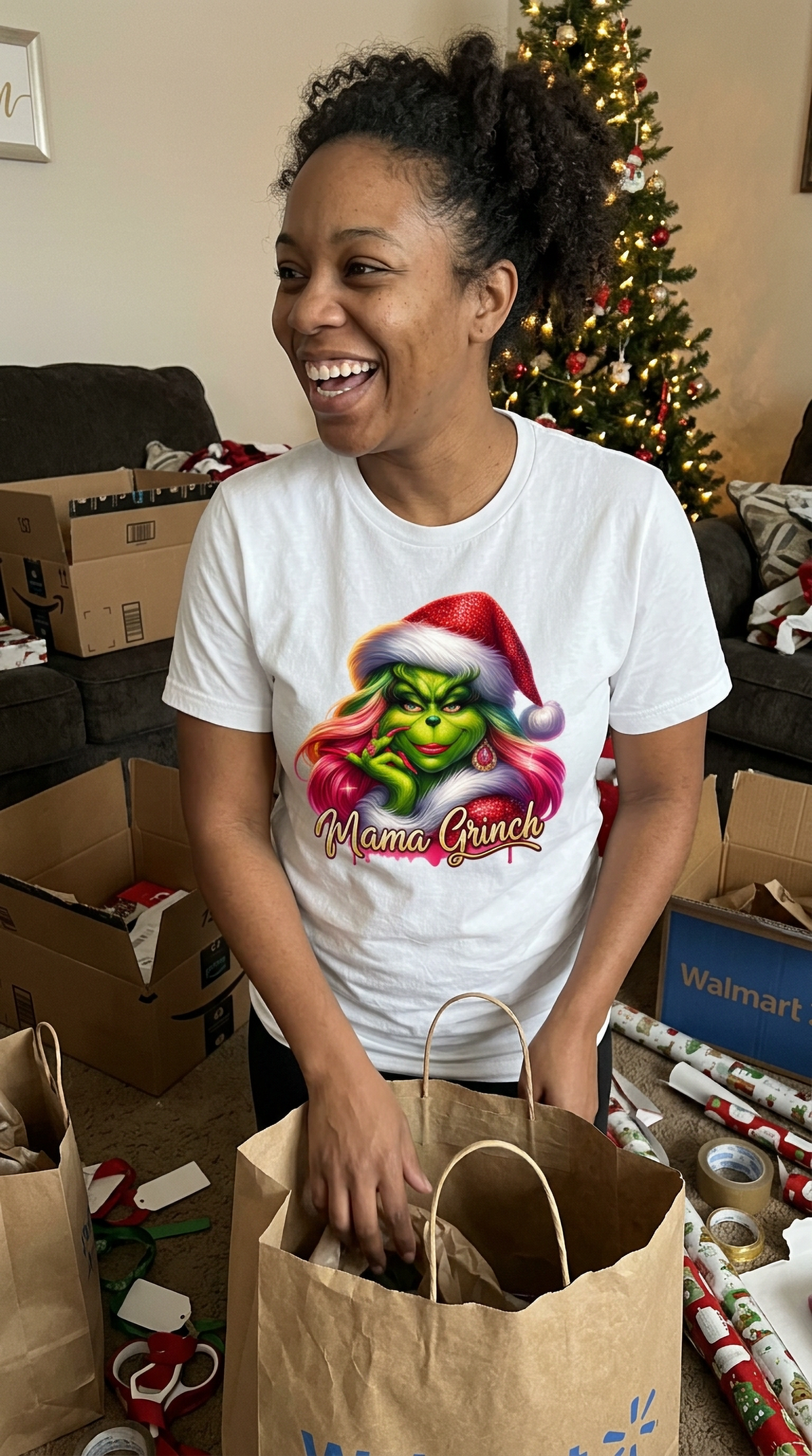 Smiling woman wearing white Mama Grinch Christmas graphic t-shirt while preparing Christmas presents.