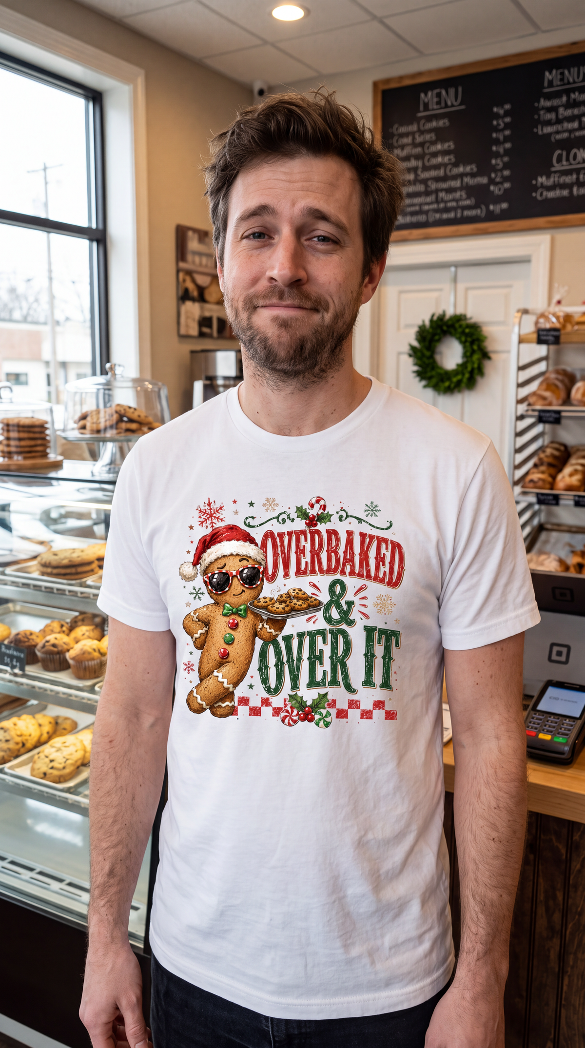 Man wearing white Overbaked and Over It gingerbread Christmas shirt with funny holiday baking graphic.