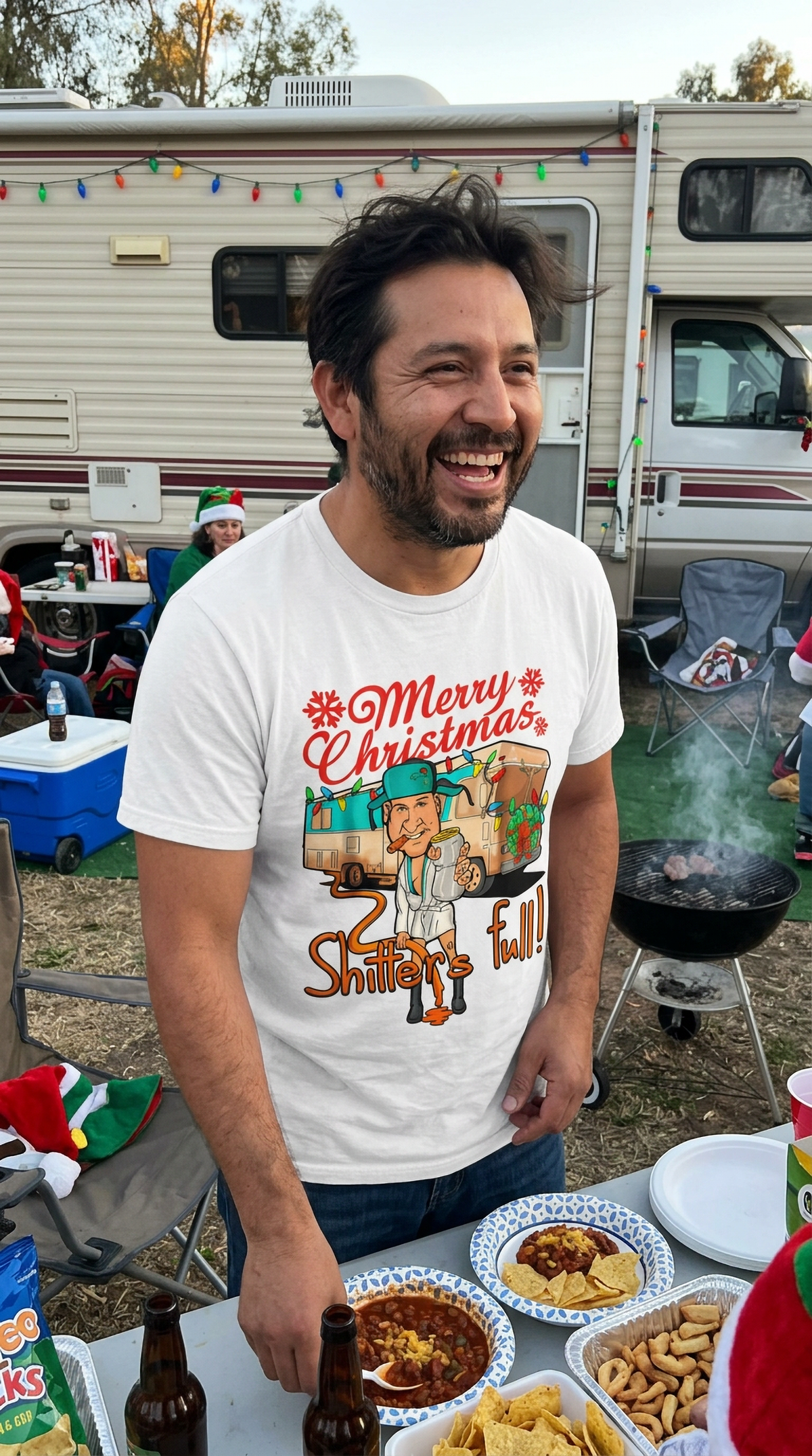 Lifestyle – White: Man wearing a white funny Christmas graphic t-shirt with a festive camper design at an outdoor holiday gathering.